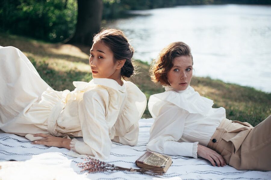 Two women in vintage Edwardian clothing by a riverside
