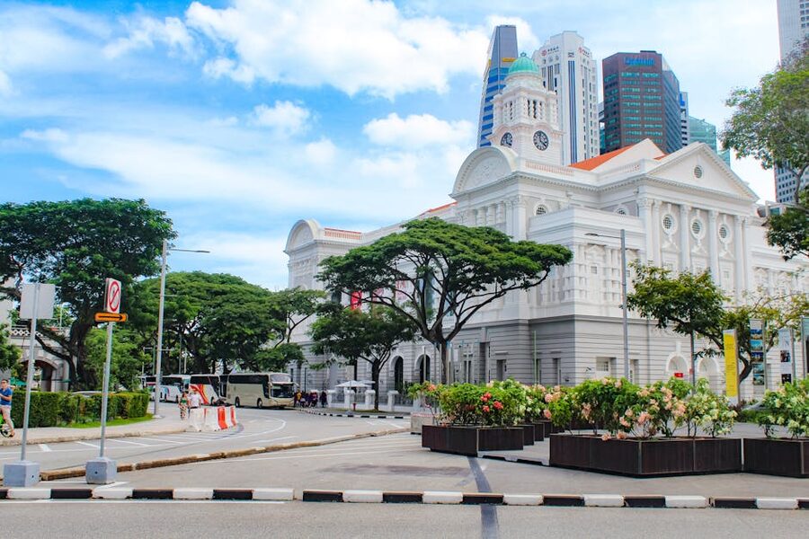 The white Gothic facade of CHIJMES Hall in Singapore at dusk surrounded by restaurants and bars