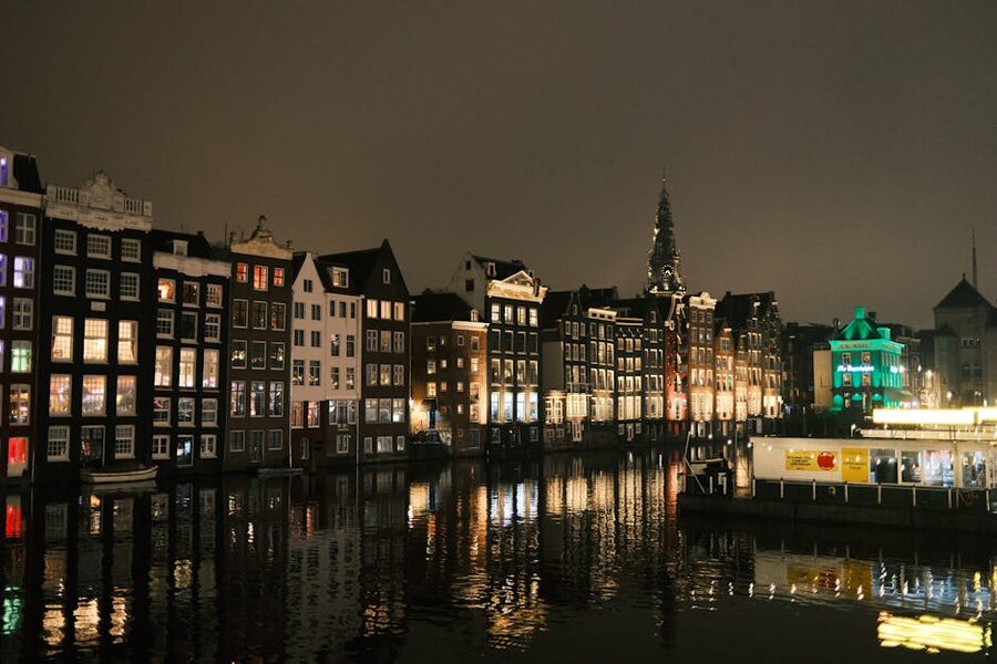 Amsterdam canal houses at night reflected in the water