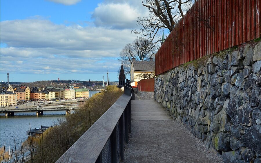Walkers and a bench on the Monteliusvägen promenade above Lake Mälaren in Stockholm