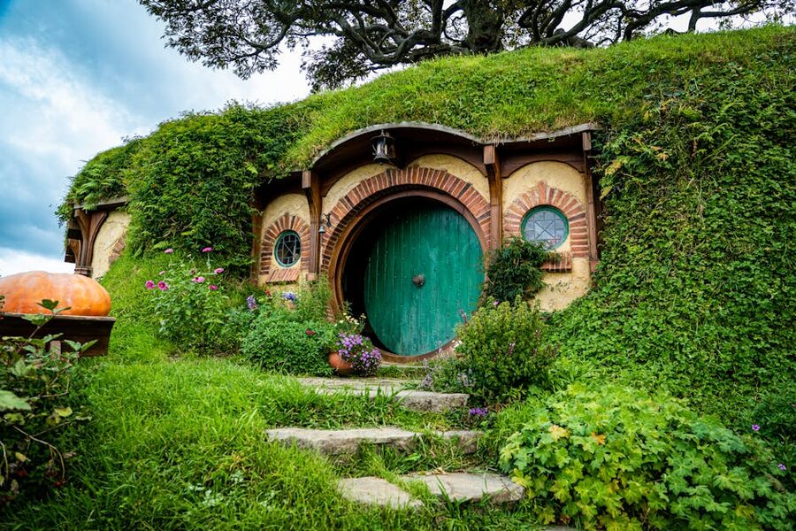 Round green door of a hobbit hole at the Hobbiton movie set with garden