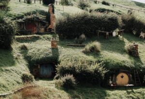 Hobbiton movie set rolling hills with hobbit holes built into the green hillside in Matamata