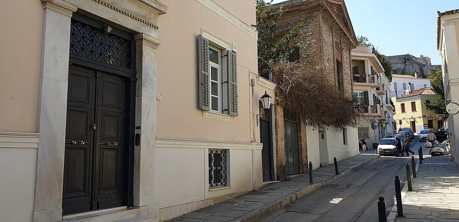 A quiet pedestrian street in the Plaka neighborhood of Athens with whitewashed walls and bougainvillea