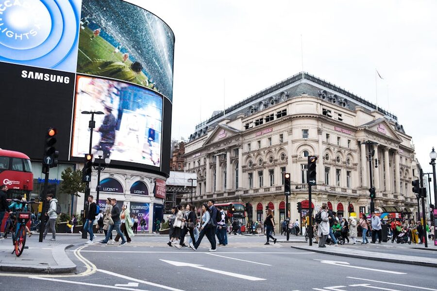Crowds and illuminated billboards at Piccadilly Circus in central London at twilight